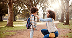 Love, mother and child with backpack in forest for back to school, getting ready and fixing shirt for support in education. Family, woman and help boy in woods for morning commute or learning journey