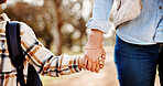 Holding hands, mom and child walking in park with safety, bonding and school backpack in park trees together. Closeup, woman and son on outdoor path for morning commute with love, trust and support