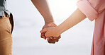 Outdoor, people and couple holding hands for bonding, support and unity on break. Outside, relationship and closeup of lovers on holiday or vacation to relax, chill and adventure for trust and care 