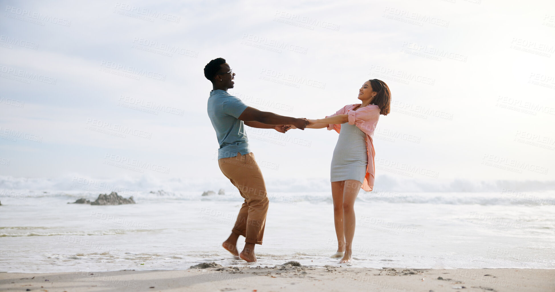 Buy stock photo Love, dance and energy with interracial couple at beach for travel destination, summer and honeymoon vacation. Relax, tropical and adventure with man and woman on date for holiday, bonding or romance