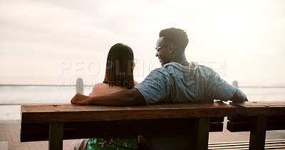 Buy stock photo Love, ocean and couple on bench for outdoor fun, bonding and care in relationship commitment. Romance, happy man and woman on date with laughing, relax and calm weekend holiday together from back