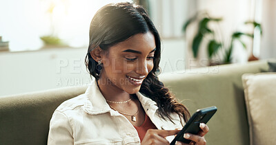 Buy stock photo Phone, relax and smile with Indian woman on sofa in living room of apartment for communication or networking. App, social media and text message with happy person in apartment on weekend afternoon