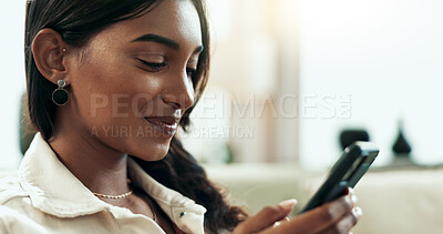 Buy stock photo App, phone and text message with Indian woman on sofa in living room of home for communication. Face, smile and social media with happy person typing in apartment for online search on internet