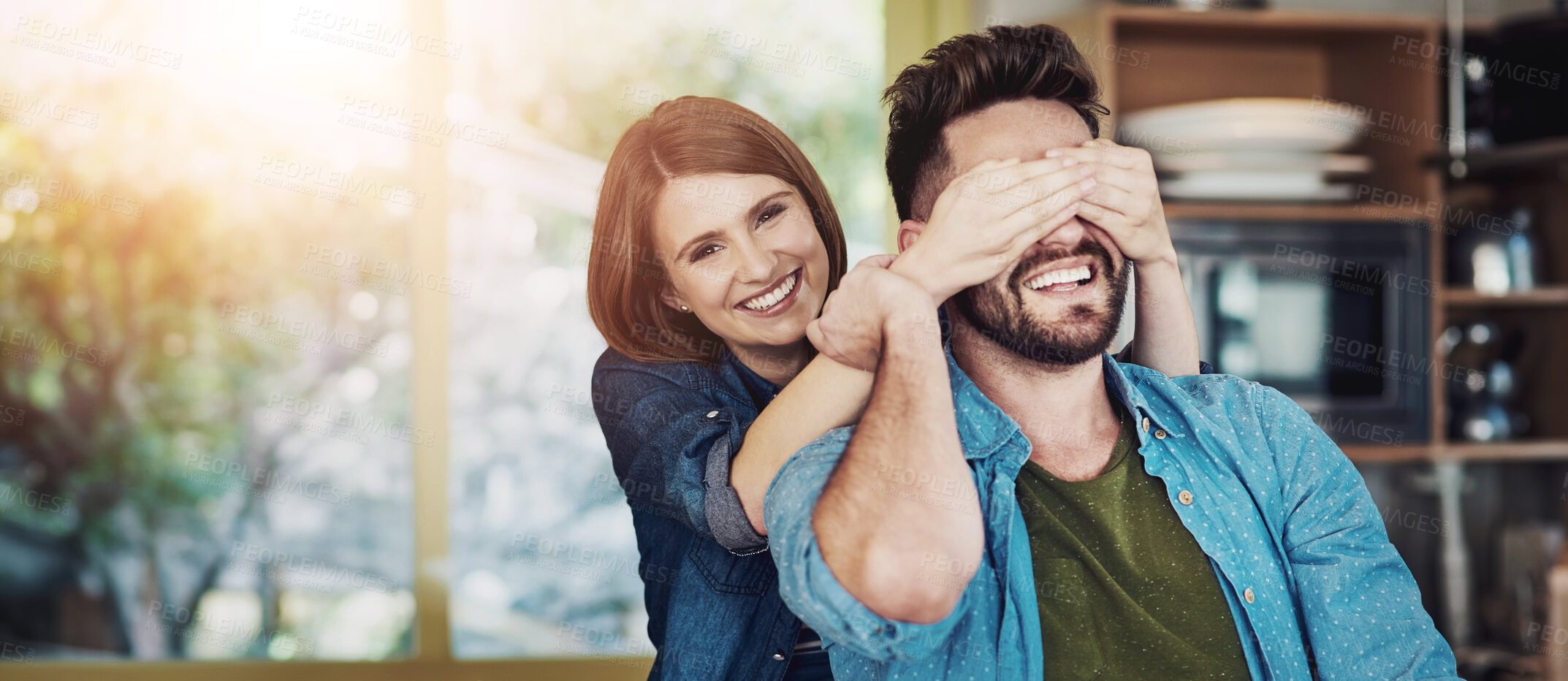 Buy stock photo Portrait of a happy young woman playfully covering her husband’s eyes