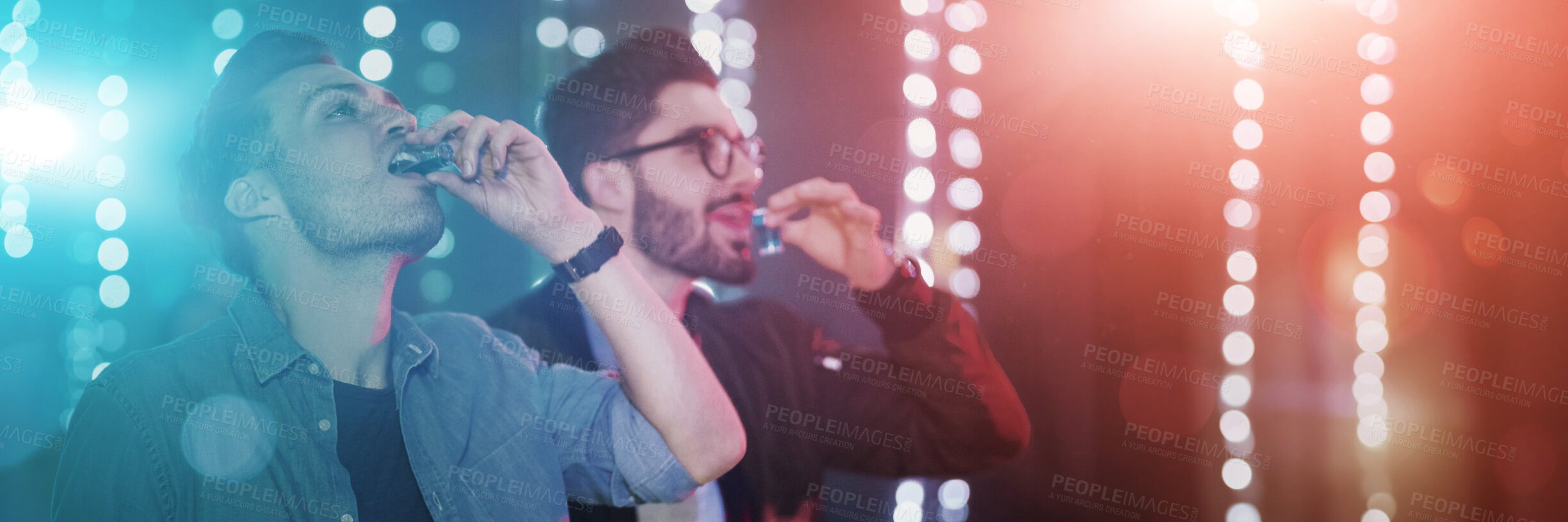 Buy stock photo Shot of two guys drinking shot at the bar counter in a nightclub