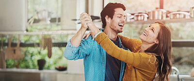 Buy stock photo Shot of an affectionate young couple dancing in their kitchen