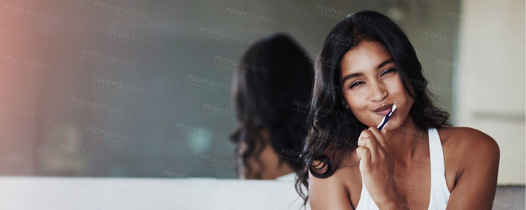 Buy stock photo Portrait of a happy young woman brushing her teeth in the bathroom at home