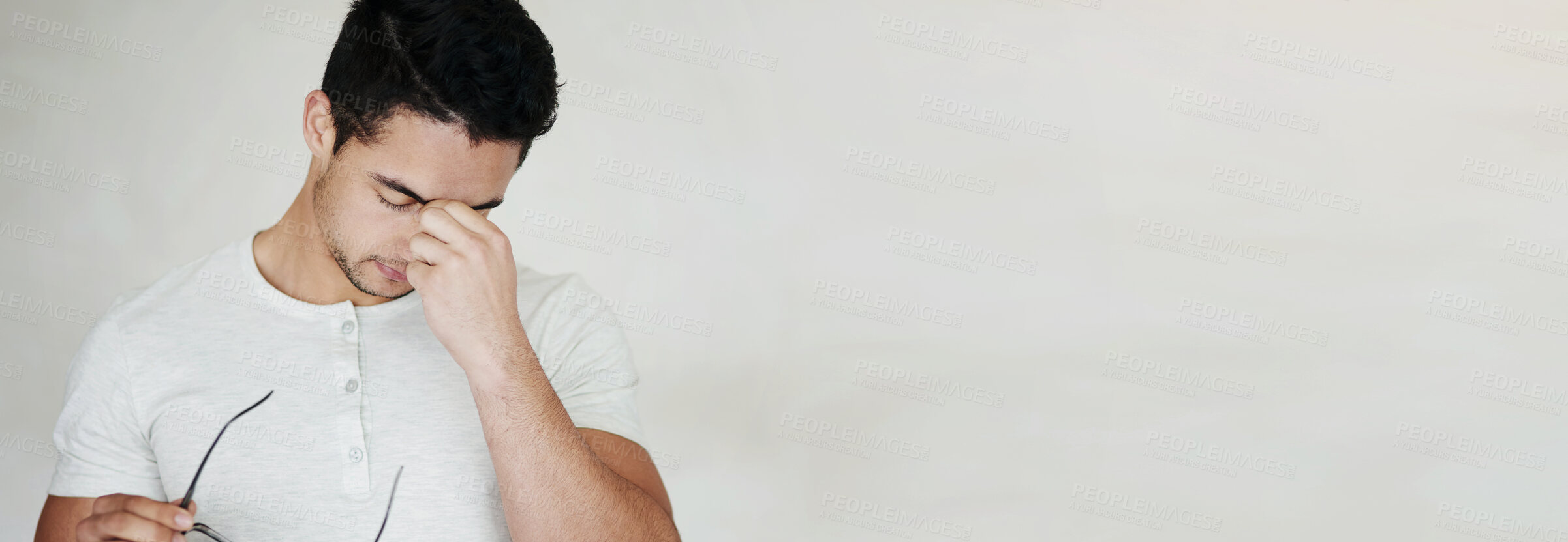 Buy stock photo Studio shot of a young man looking stressed against a light background