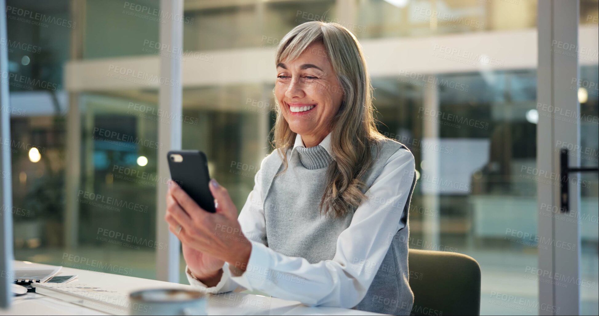 Buy stock photo Mature woman, office and typing on phone for online chat, business communication or contact at night. Overtime, smartphone and happy businesswoman reading email, review or message at digital agency