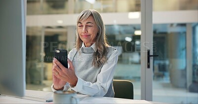 Buy stock photo Mature woman, office and checking phone for online chat, business communication or contact at night. Overtime, smartphone and senior businesswoman reading email, review or message at digital agency