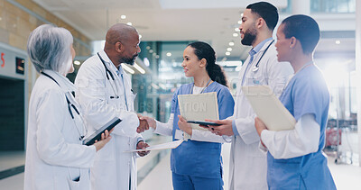 Buy stock photo Woman, doctors and handshake with group in hospital corridor with welcome, introduction and happy. People, medical staff and shaking hands with diversity, teamwork or onboarding at wellness clinic