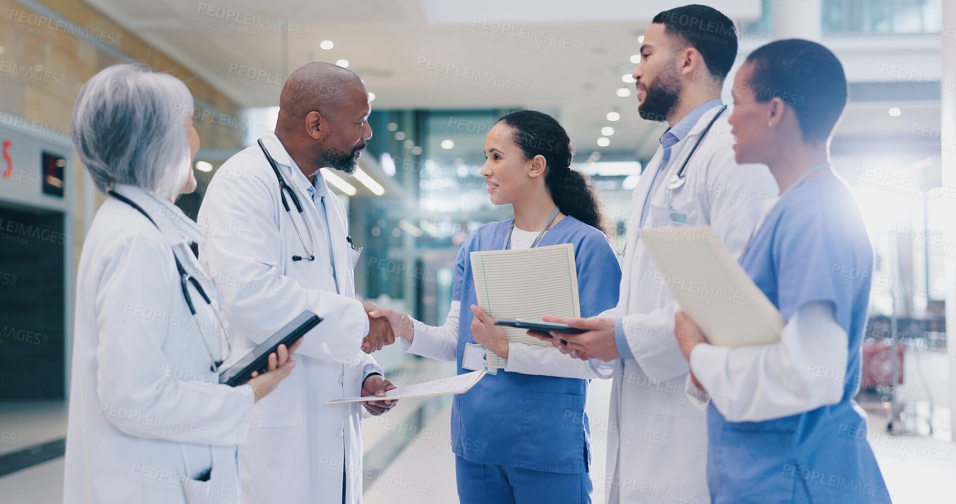 Buy stock photo Woman, doctors and handshake with group in hospital corridor with welcome, introduction and happy. People, medical staff and shaking hands with diversity, teamwork or onboarding at wellness clinic