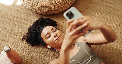 Buy stock photo Girl, rest and happy on floor with earphones, mobile phone and scroll in home for online yoga class. Female person, technology and above for connection, streaming or podcast on break or relax for zen