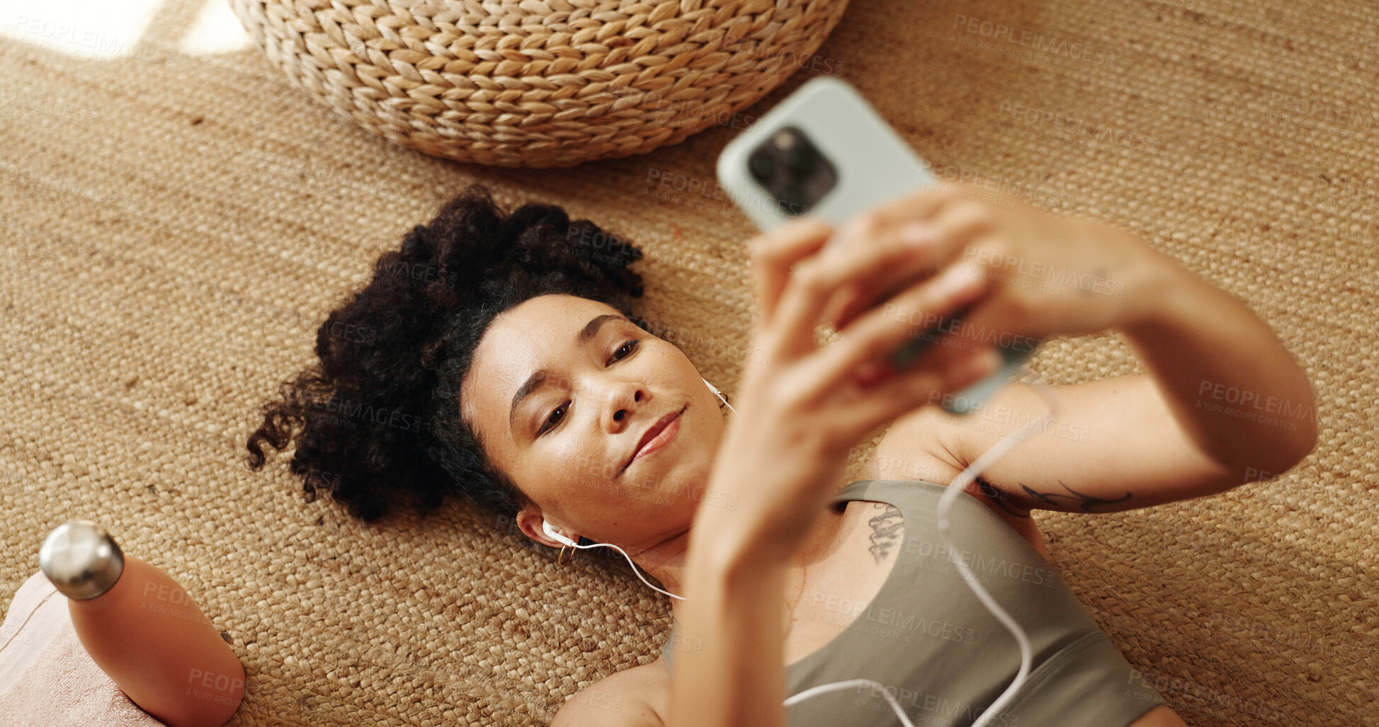 Buy stock photo Girl, rest and happy on floor with earphones, mobile phone and scroll in home for online yoga class. Female person, technology and above for connection, streaming or podcast on break or relax for zen