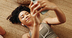 Girl, relax and happy on floor with earphones, mobile phone and scroll in home for online yoga class. Female person, technology and above for connection, streaming or podcast on break or rest for zen