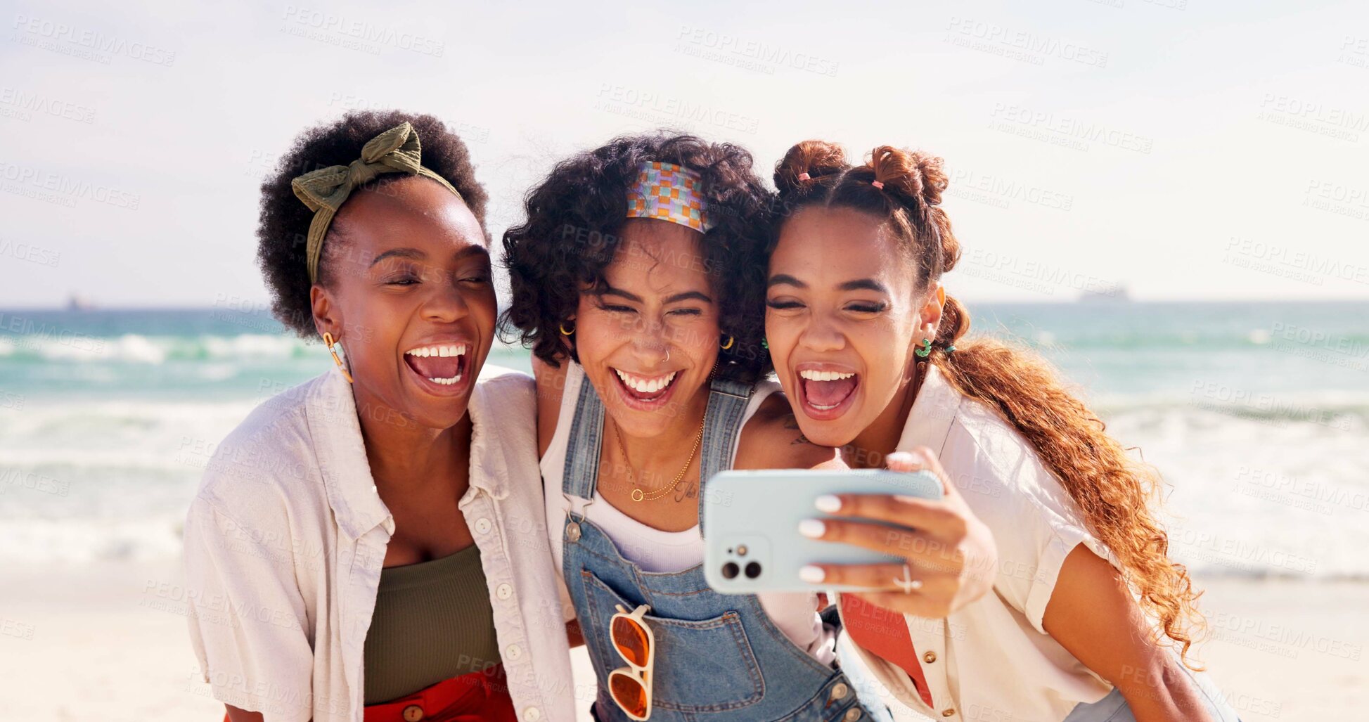 Buy stock photo Happy women, friends and laughing with selfie at beach for funny holiday or summer vacation together. Young, group or female person with smile, hug or humor for picture, memory or moment by ocean