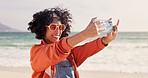 Happy woman, sunglasses and beach with selfie for memory, photography or picture in nature. Young, female person or hipster with smile for style, moment or capturing holiday vacation by ocean coast