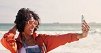 Happy woman, sunglasses and beach with selfie for fashion, memory or photography in nature. Young, female person or hipster with smile for style, moment or capturing holiday vacation by ocean coast