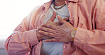 Closeup, hands and senior person with chest pain in retirement, heart attack and cardiac arrest in home. Female pensioner, old woman and discomfort in zoom for angina, asthma and heartburn in house