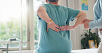 Back pain, physiotherapy and office with people in consultation for medical, support and recovery. Woman, injury and patient with assessment for osteoporosis, rehabilitation or physiotherapist advice