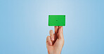 Hand, green screen and business card in studio mockup for recruitment, offer and contact detail. Person, chroma key plastic and tracking markers on blue background space for banking, payment or promo