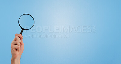 Buy stock photo Magnifying glass, search and hand of person in studio for detail, investigation and discovery. Arm, lens and inspection with tool by mockup space for info, analysis and solution on blue background