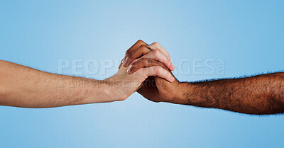 Buy stock photo Care, unity and people holding hands in studio for change, collaboration and kindness in solidarity. Friends, love and gesture of support on blue background for human rights, trust or racial equality