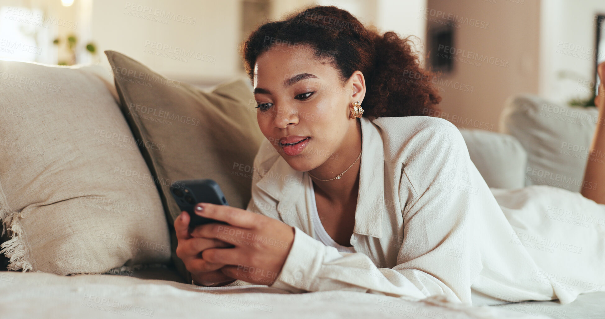 Buy stock photo Phone, relax and woman typing on sofa on social media account for streaming, subscribe or like video. Mobile, home and African girl on app to scroll blog online, text and reading message on internet