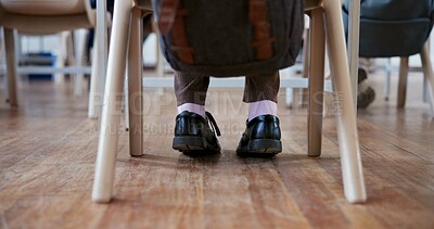 Buy stock photo Student, child and feet in classroom for learning with shoes, backpack and studying at desk for scholarship. Person, chair or legs at school with knowledge for development, academy or lesson on floor