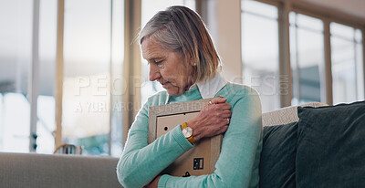 Buy stock photo Crying, hug and senior woman with picture frame for mourning, loss or grief with memory in home. Sad, nostalgia and elderly female person embracing photo for reflection or remembrance of past love.