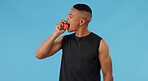 Man, apple and bite for nutrition in studio, athlete and eating fruit for diet on blue background. Male person, sportsman and healthy snack for vitamins or minerals, weight loss and fiber for detox