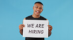 Man, board and hiring in studio portrait with smile, fitness and onboarding sign by blue background. Personal trainer, happy and present poster with recruitment for onboarding gym staff in Colombia