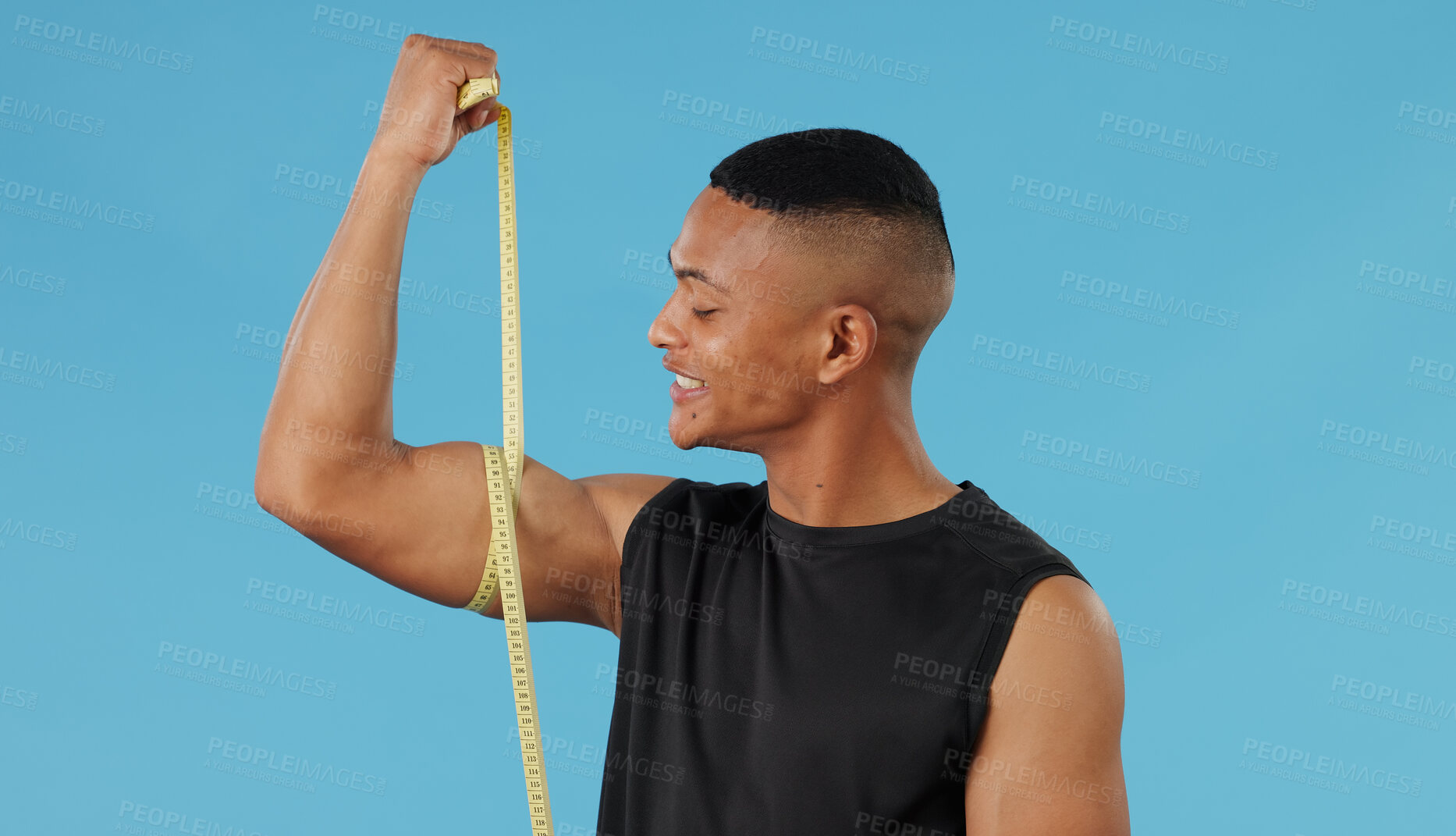 Buy stock photo Man, arm and measuring muscle in studio, check and bodybuilder flexing on blue background. Male person, fitness and strong guy for results of weightlifting, monitor progress and tool for development