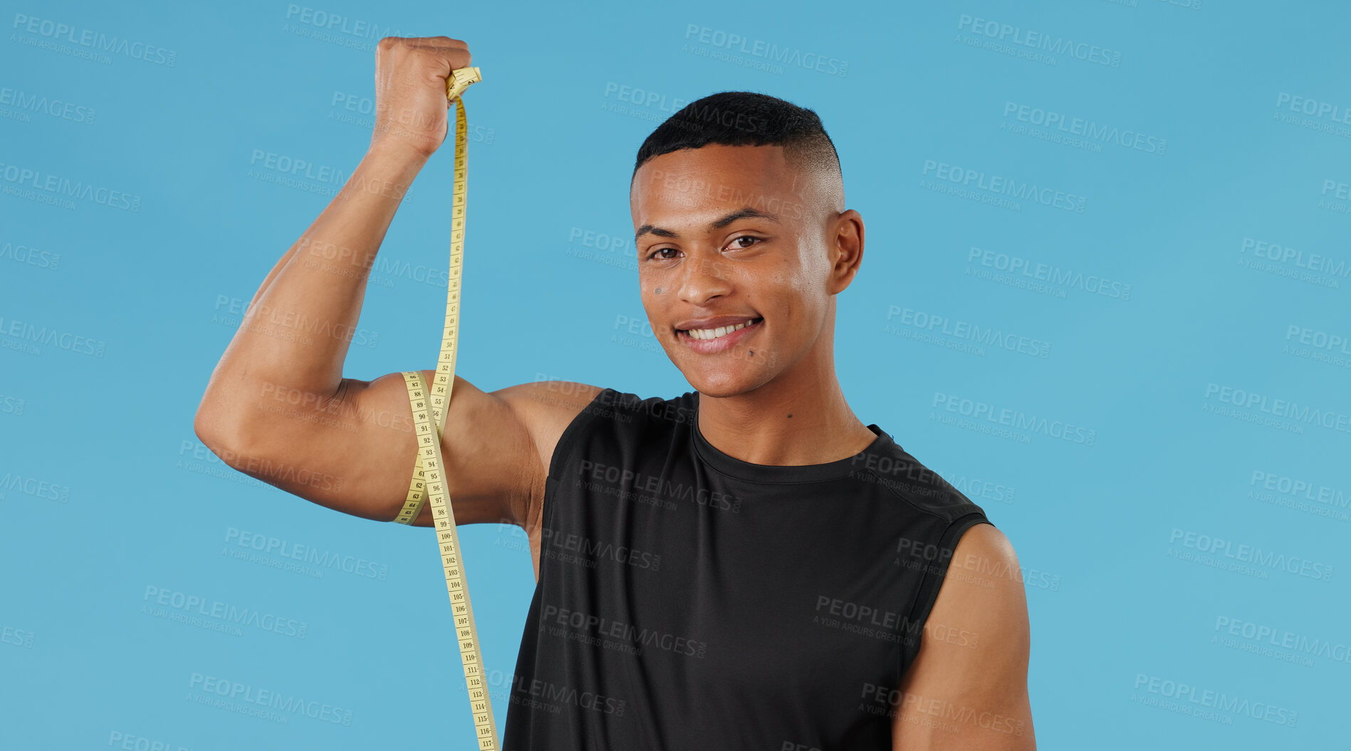 Buy stock photo Man portrait, bicep and measuring muscle in studio, check and bodybuilder flexing on blue background. Male person, fitness and results of weightlifting, monitor arm progress and tool for development