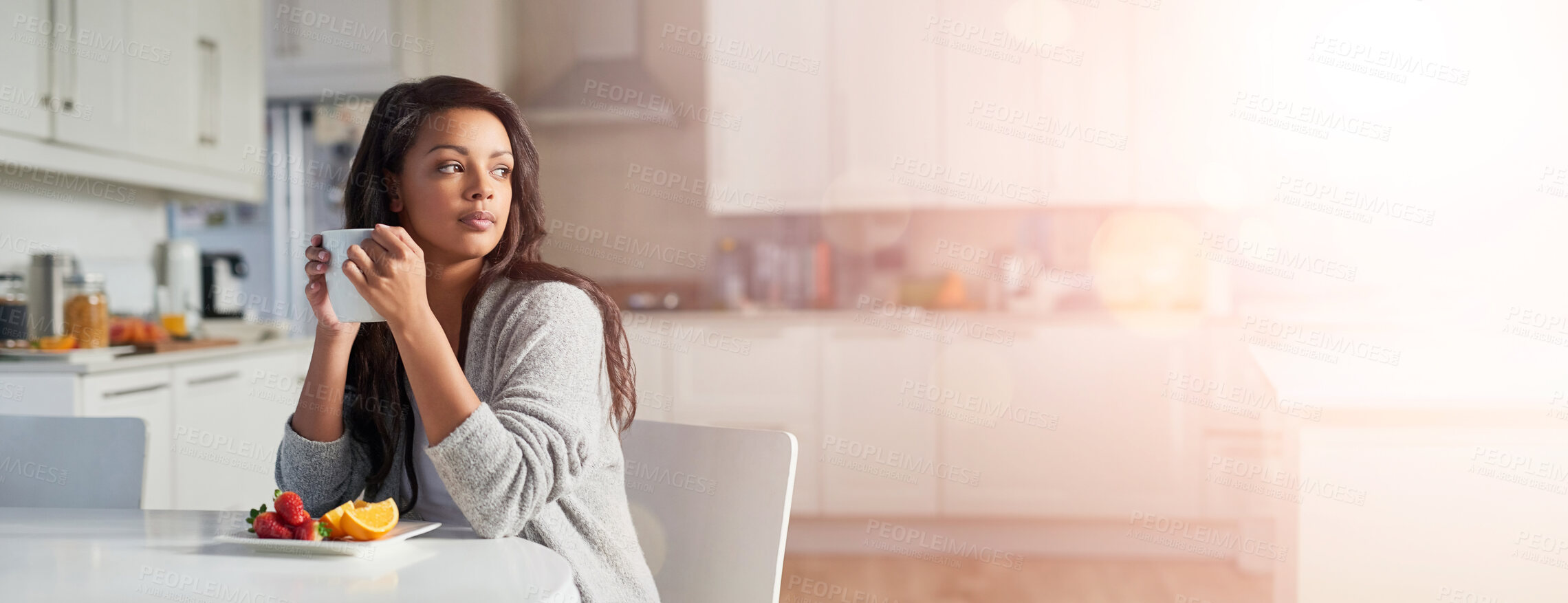 Buy stock photo Shot of young woman daydreaming while enjoying breakfast in her kitchen at home