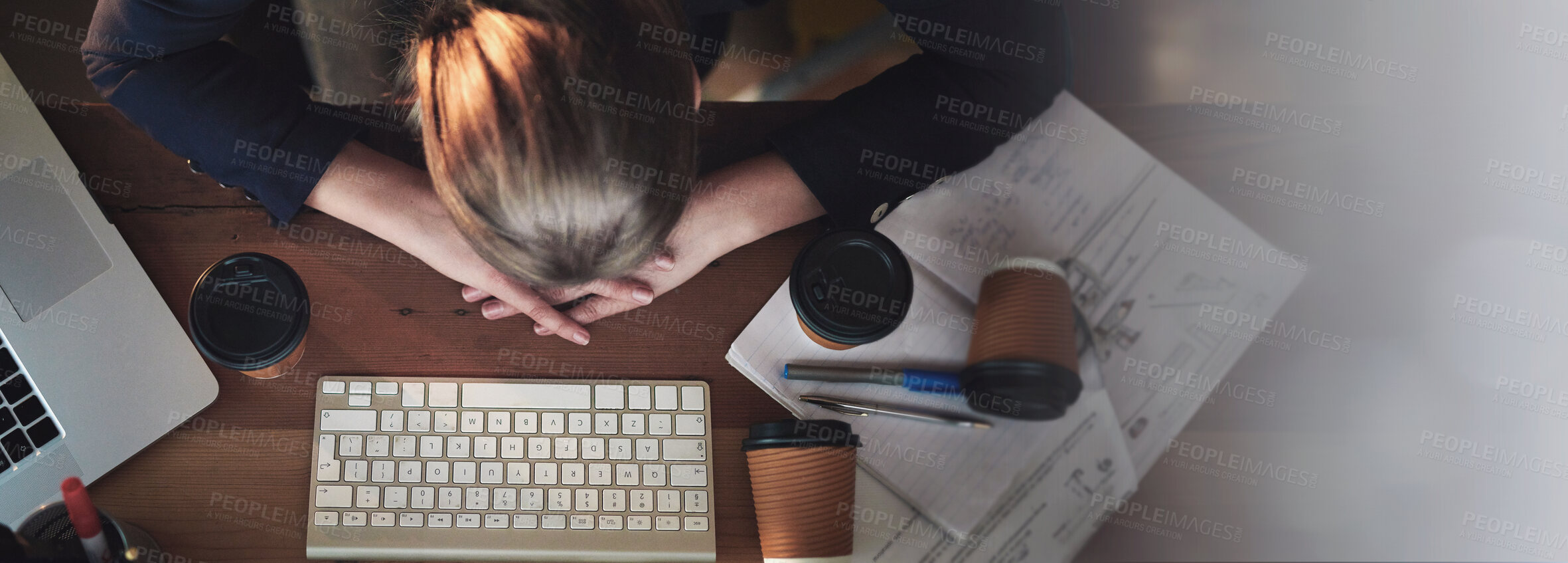 Buy stock photo Shot of a tired young designer napping on her desk wile working late in the office