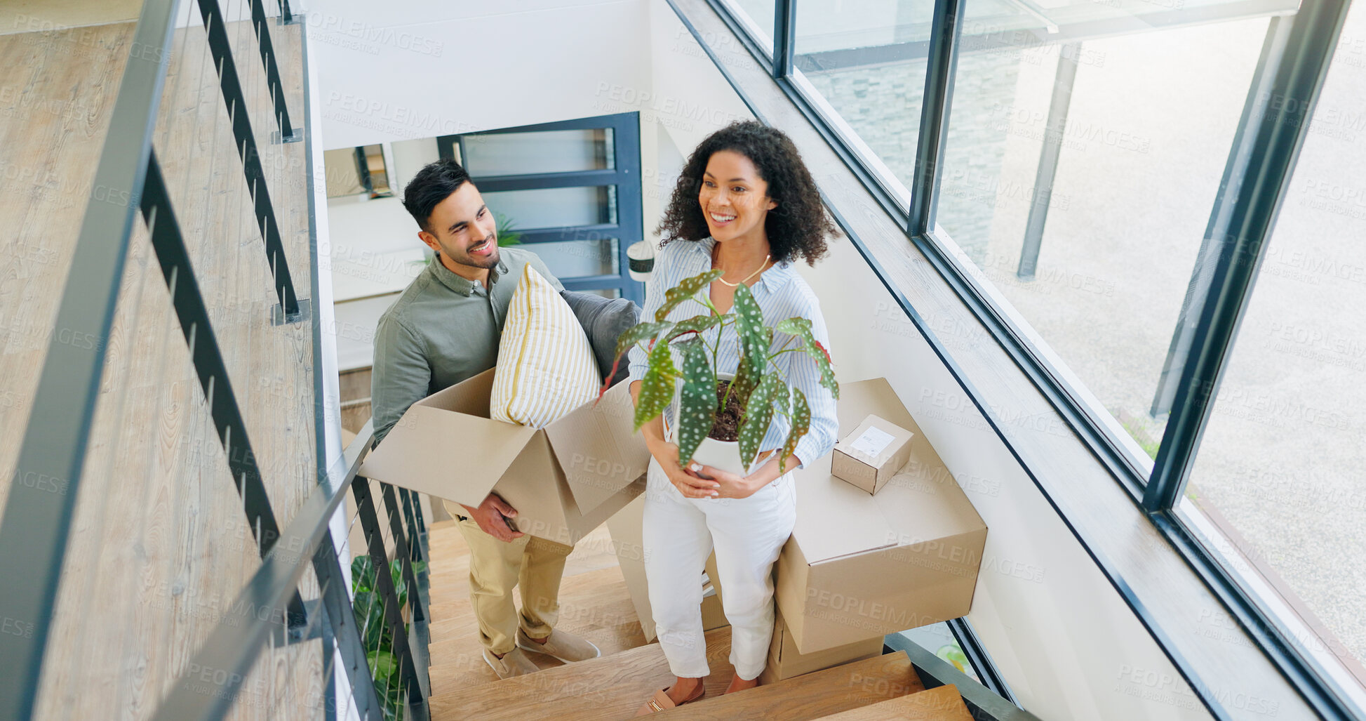 Buy stock photo Couple, moving and above with box in portrait for property, investment and packing for new home. Happy, man and woman with cardboard package by stairs for real estate, mortgage and marriage residence