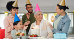 Family, happy and celebration with grandma on birthday for present, surprise and special event at home. Party hat, child and people with applause by senior woman for dessert, cake or candles by table