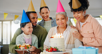 Buy stock photo Home, family and celebration with grandmother on birthday for surprise, present and happy event. Party hat, people and child with smile by senior woman for cake, candles and support on special day