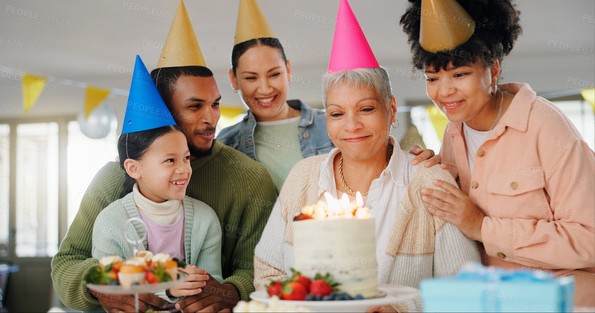 Buy stock photo Home, family and celebration with grandmother on birthday for surprise, present and happy event. Party hat, people and child with smile by senior woman for cake, candles and support on special day