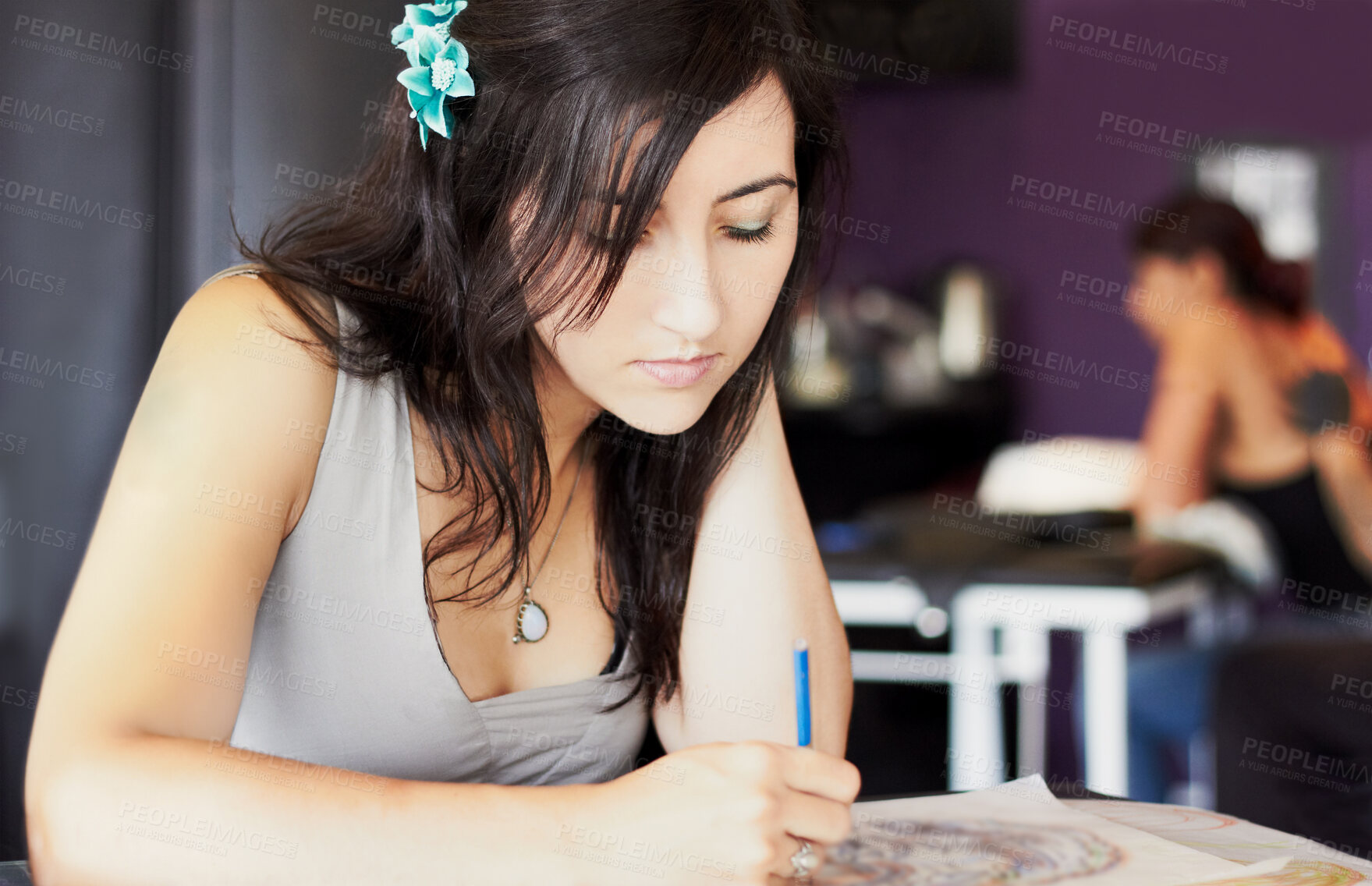 Buy stock photo A female tattoo artist drawing a new design while in her tattoo parlour