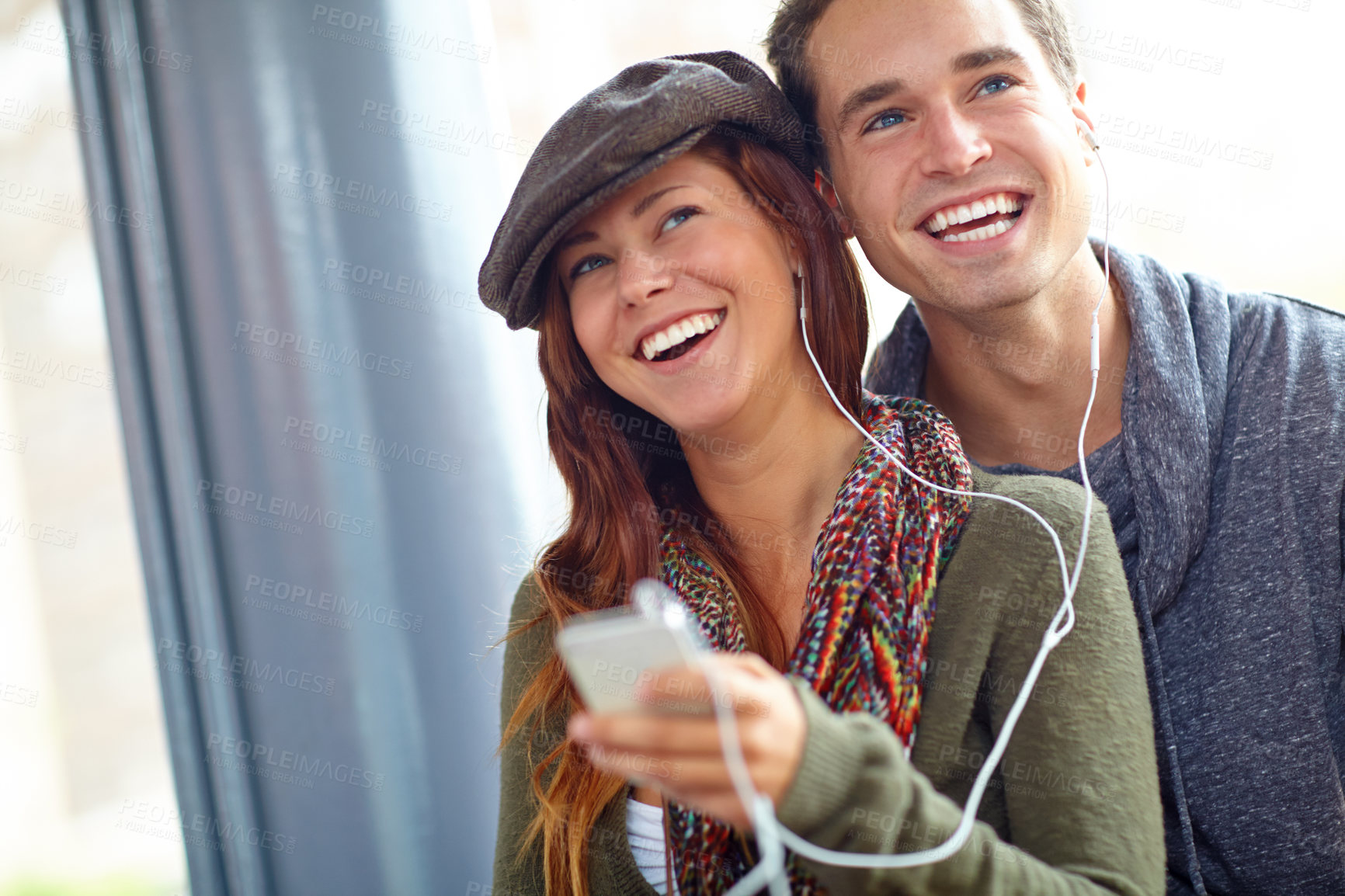 Buy stock photo Laugh, music and journey with couple at bus station. for holiday, streaming and smile together. Audio, public transportation and podcast with people at subway for support, adventure and date