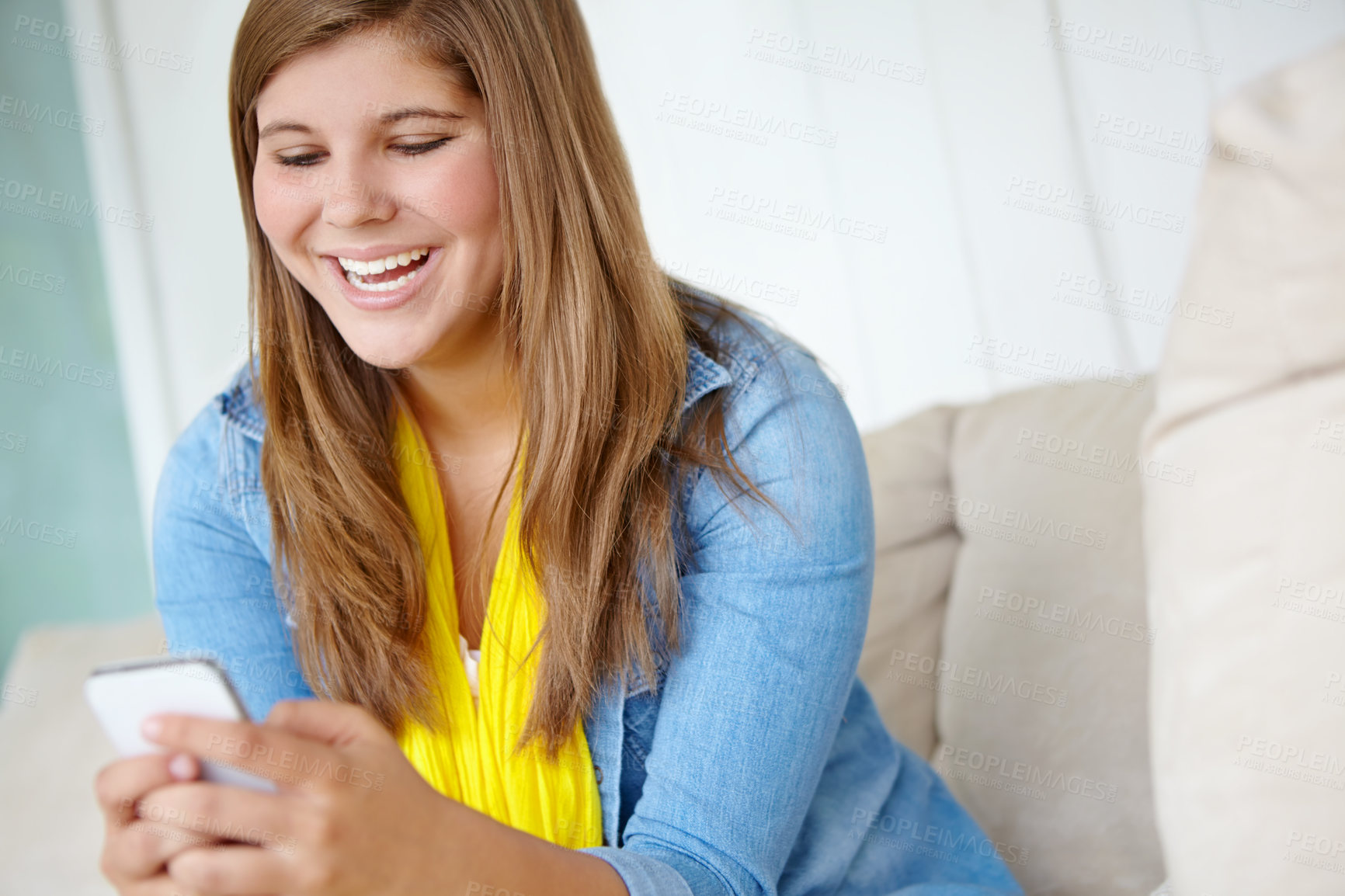 Buy stock photo Sofa, smile and young woman with phone at home for social media, notification and reading message. Happy, relax and female person with technology in living room for internet, connection and texting