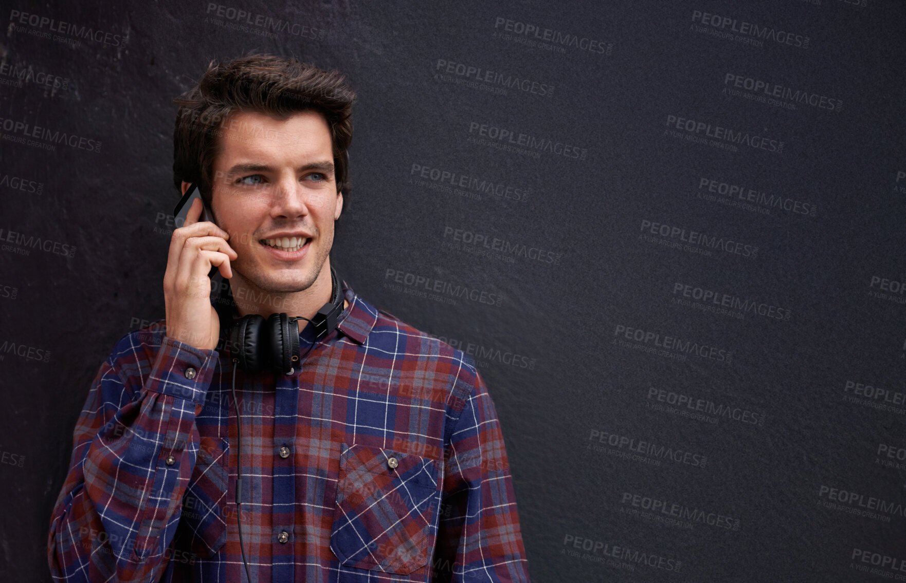 Buy stock photo Man, phone call and happy by wall in city with chat, listening and conversation with mobile connection. Person, smartphone and college student with contact, smile or outdoor on metro street in Italy