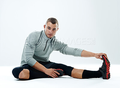 Buy stock photo Portrait, stretching and man with fitness, athlete on floor and healthy guy on white studio background. Face, person and model with exercise, workout and challenge with wellness, warm up and balance