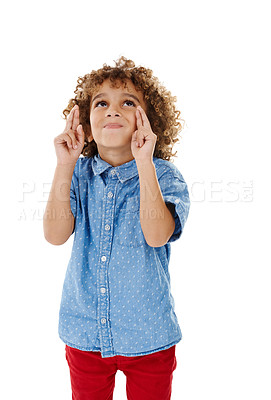 Buy stock photo Kid, thinking and fingers crossed in studio for luck, hope and excited for competition draw. Boy child, hand gesture and wish on white background for miracle, faith and optimism for good news or win