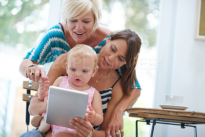 Buy stock photo Happy, lesbian parents and tablet with child adoption and love with family home, bonding or relax. Female people, foster mom and technology in house, lounge or apartment on weekend as lgbt community