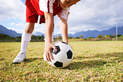 Buy stock photo Child, hands and soccer ball for sports on green grass in training or practice with clouds and blue sky. Closeup of young football player ready for kick off game or match on outdoor field in nature