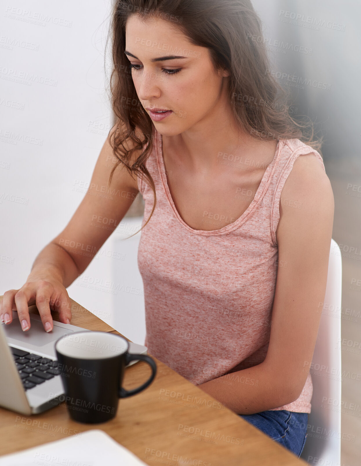 Buy stock photo A young woman working on her computer from home