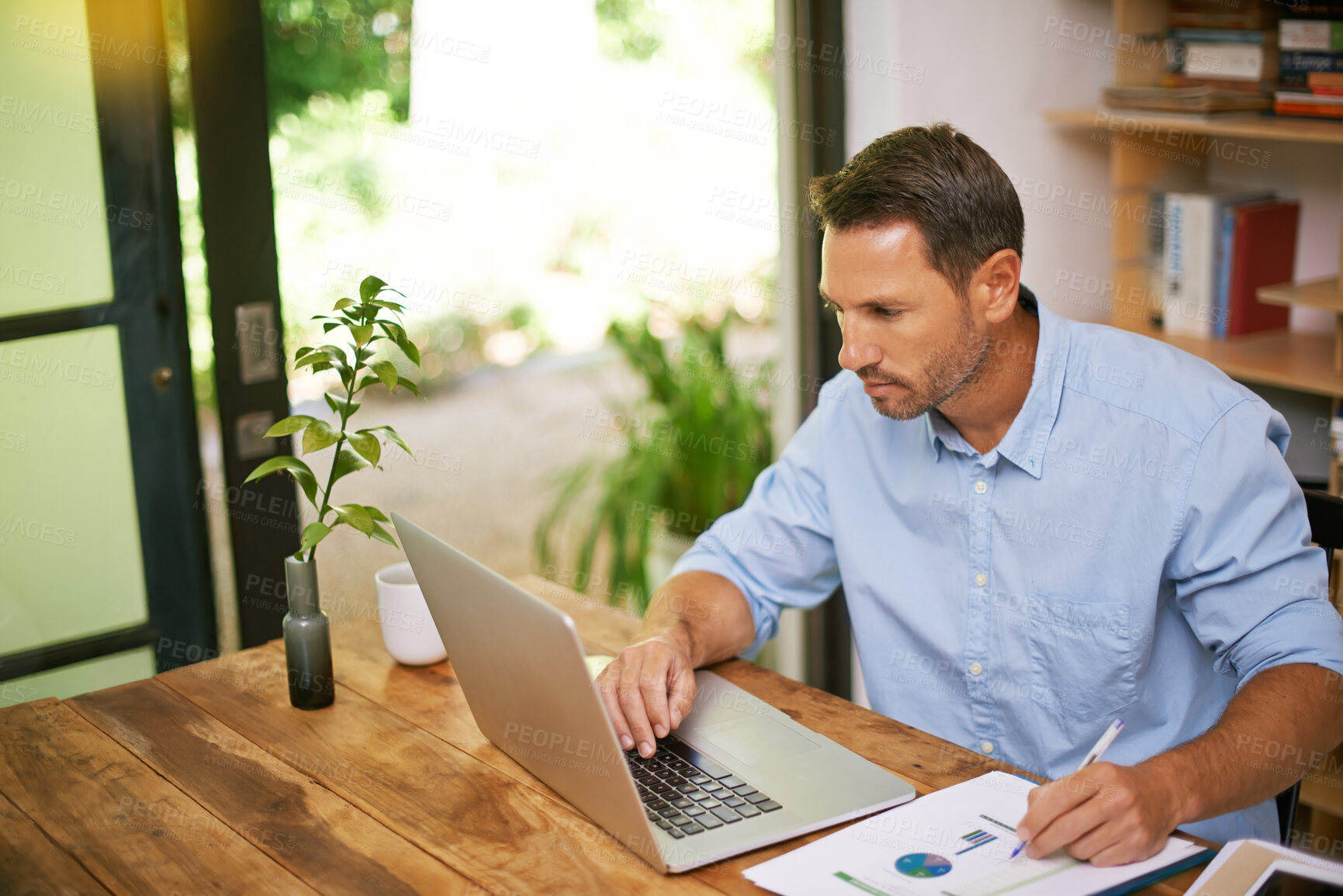 Buy stock photo Laptop, graph and business man in home with documents for financial review, research and annual report. Remote work, freelance and person on computer with paperwork, charts and statistics for finance